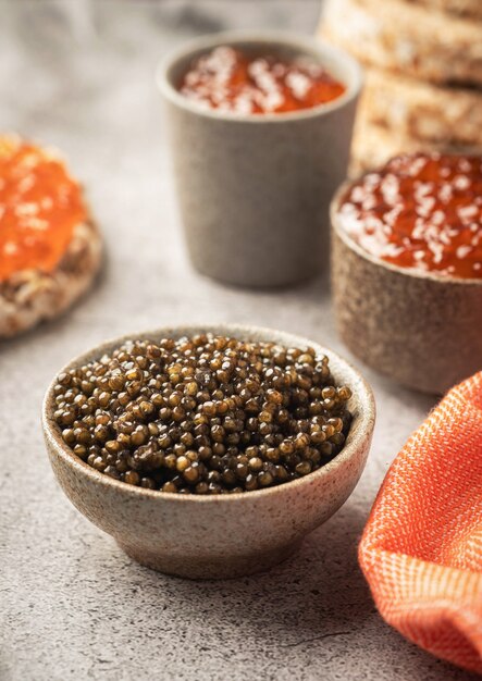 red caviar in bowl on a gray concrete surface