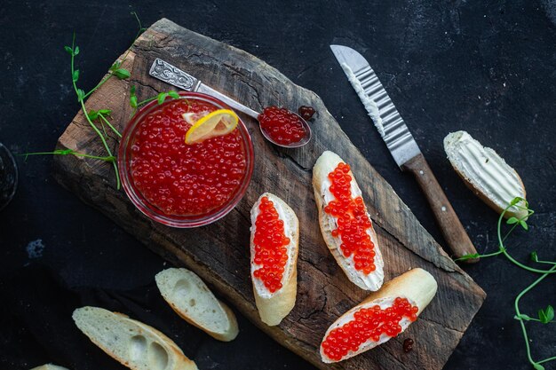 Red caviar on a dark background Sandwiches with caviar