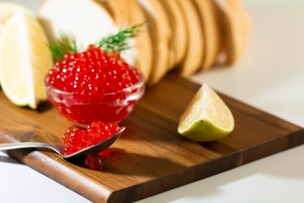 Red caviar in glassware on wooden background with space for text