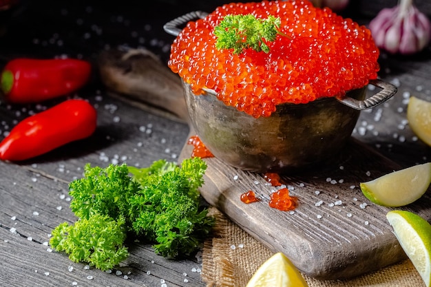 소박한 빈티지 스타일의 빨간 캐비어, 나무 커팅 보드와 t에 양동이 냄비의 깊은 그릇