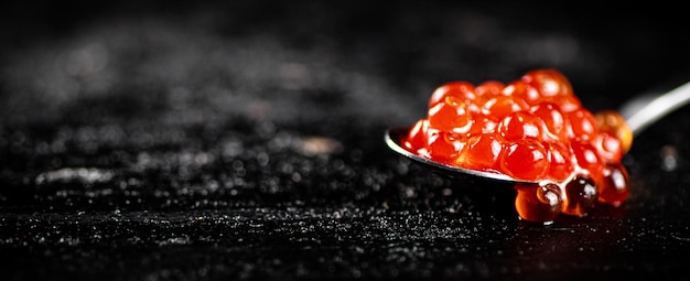 Photo red caviar in a spoon on the table