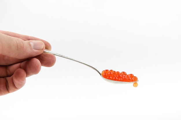 red caviar and a spoon on a white background