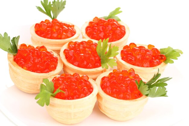 Red caviar in tartlets on white plate closeup