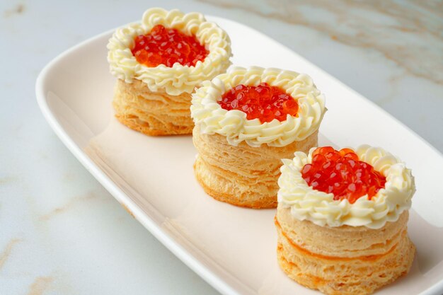 Red caviar in tartlets on white plate