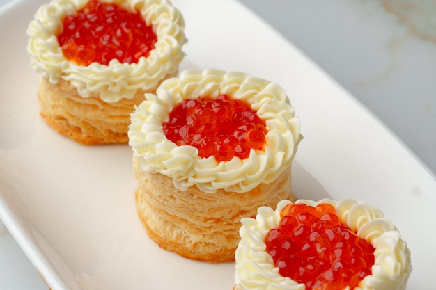 Red caviar in tartlets on white plate