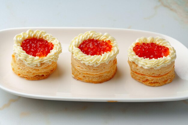 Red caviar in tartlets on white plate