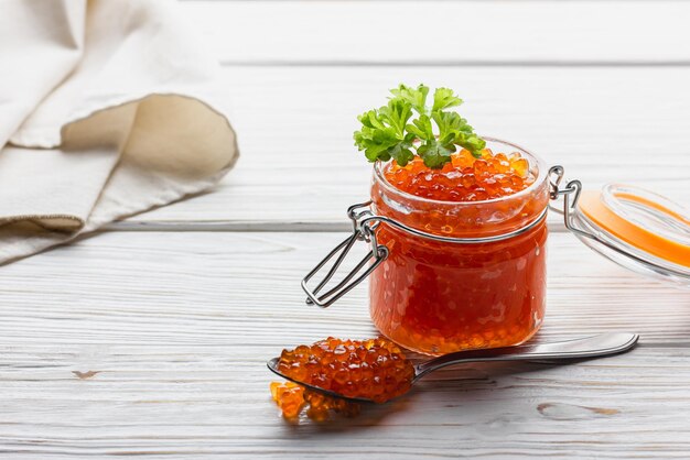 Red caviar with parsley in jar and in spoon