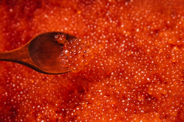 Red caviar in a wooden spoon.