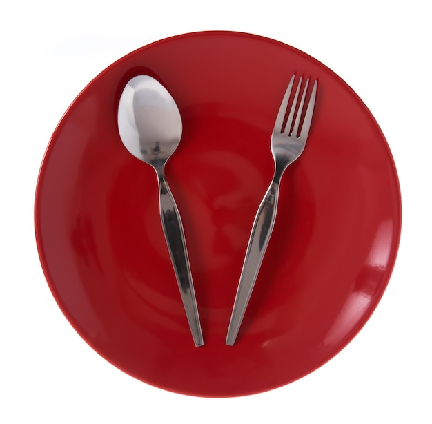 red ceramic dish with aluminium fork and spoon isolated on white background