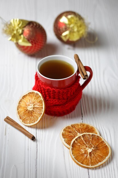 Foto tazza di tè in ceramica rossa con decorazioni natalizie invernali su un tavolo di legno focus selettivo