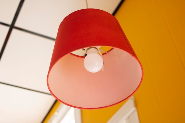 Red chandelier with a light bulb on the ceiling