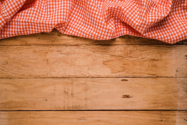 Photo red checkered table cloth at the top of old wooden worktop
