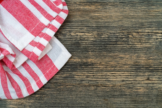 Red checkered towel on the kitchen table. Wooden table background.