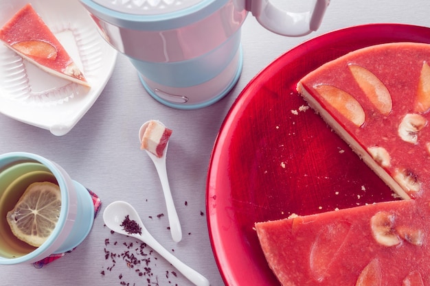 Foto decorazione di cheesecake rossa di nettarine con tè