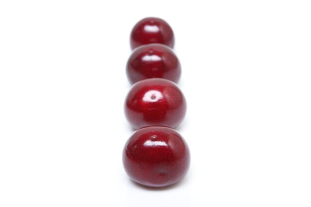 Red cherries isolated on white background. Fresh summer dark red sweet cherries closeup