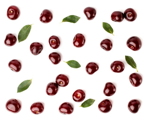 Red cherries and leaves scattered on white, top view. Fruit.