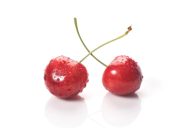 Red cherries with water droplets, close-up. Isolated on white background.