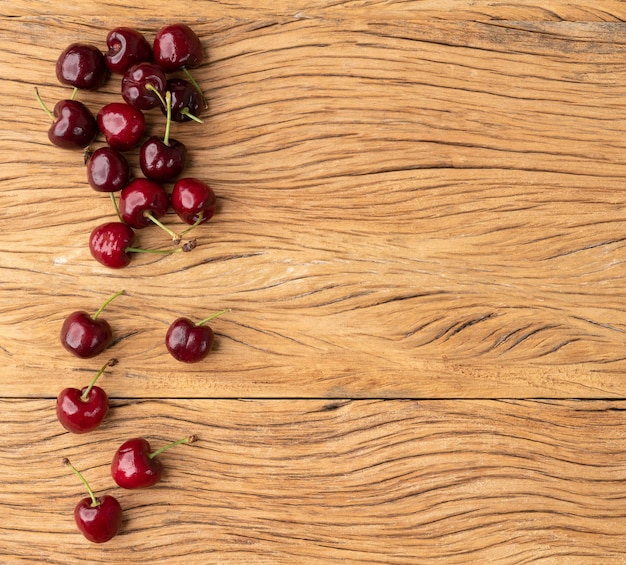 Ciliege rosse sopra il tavolo di legno con lo spazio della copia