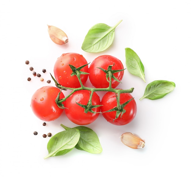 Red cherry tomatoes and basil on white background