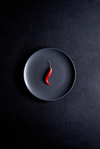 Foto peperoncino rosso in lamiera nera
