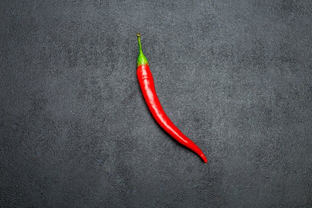 Red chili pepper on dark concrete background