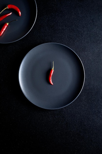 Фото Красный перец чили в черной тарелке