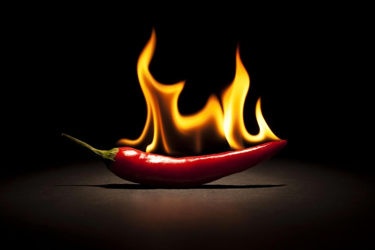 Photo a red chili pepper is being consumed with flames.