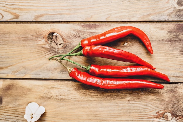 Red chili pepper pods on a wooden background