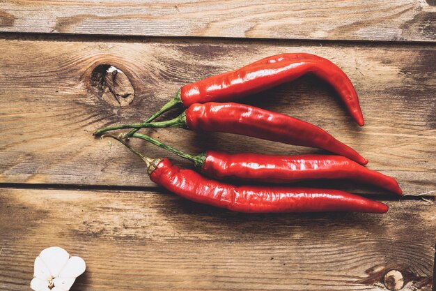 Red chili pepper pods on a wooden background