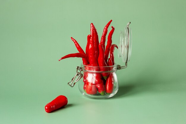 Red chili peppers in a glass jar, conservation concept. Place for your text.