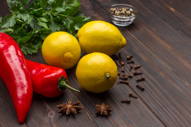 Foto peperoncino rosso, spezie verdi di limone sul tavolo. avvicinamento. copia spazio. superficie in legno scuro. vista dall'alto