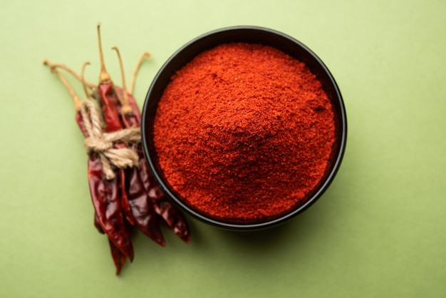 Red Chilli or Lal Mirchi or mirch with Powder in a bowl or mortar over moody background, selective focus
