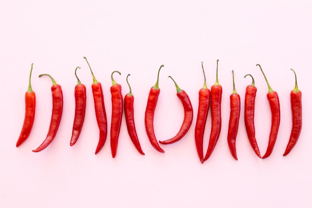 Red chilli pepper on a pink background vegetable pattern Pattern of food Top viewflat lay