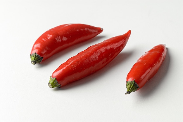 Red chilli peppers on white background.