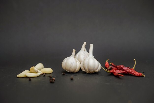 Photo red chilli peppers with garlic cloves on black background