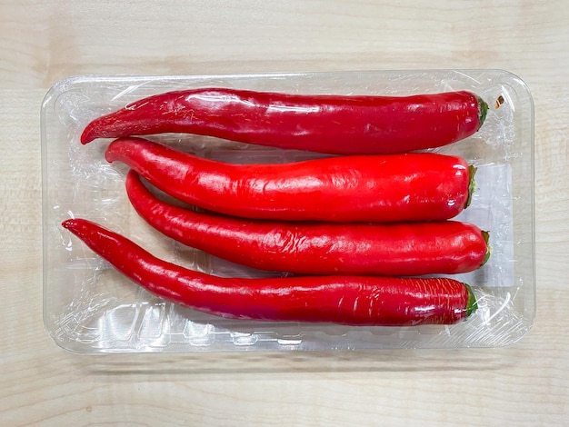 Red chilli spur peppers in plastic pack on the table