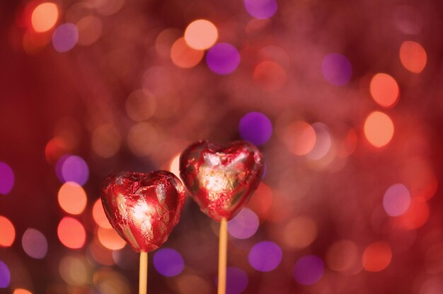 チョコレートハートのバレンタインデースタックのために赤いホイルで包まれた赤いチョコレートハート