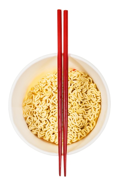 Photo red chopsticks on open cup with instant noodles