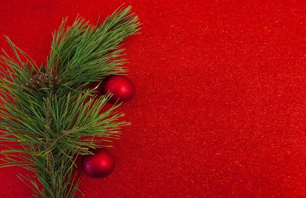 Red Christmas background with Christmas tree branch and Christmas balls and toys