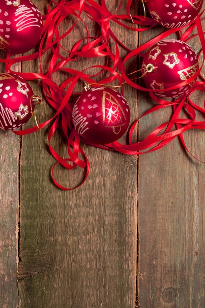 Red Christmas ball and ribbons on wooden.