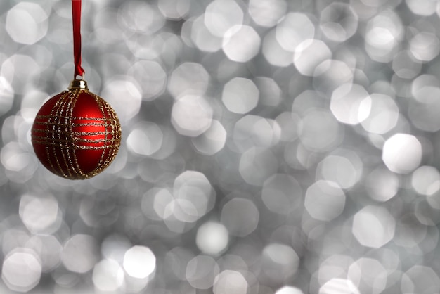 Red Christmas ball on silver blurred background