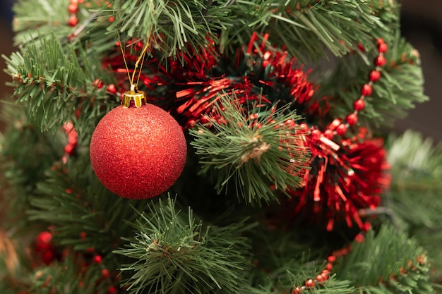 Red christmas ball on the tree with beads