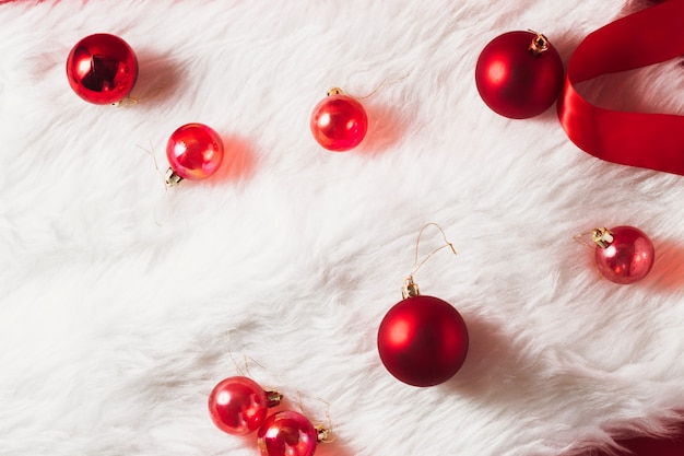 Red Christmas balls on a fur with a red ribbon