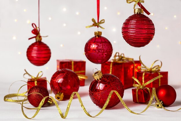 Red Christmas balls, serpentine and New Year's gifts on a light background