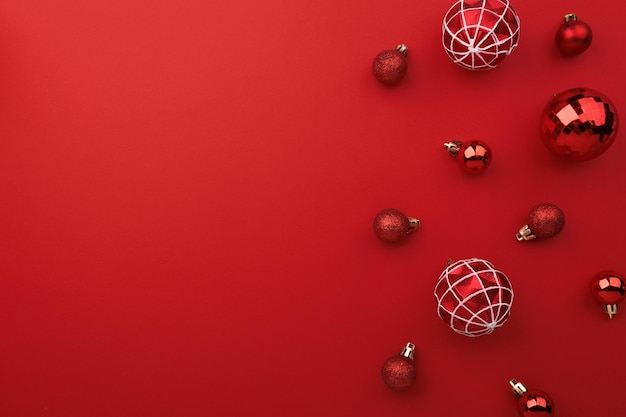 Photo red christmas baubles decoration on red background with copy space flat lay