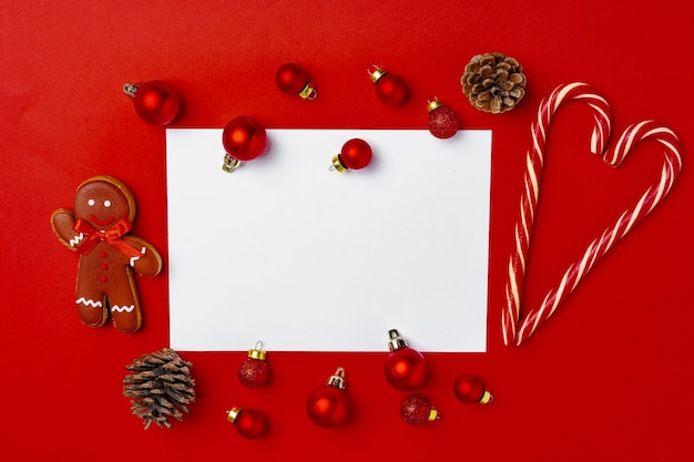 Foto bagattelle rosse di natale con la pagina vuota mock up per biglietto di auguri sul rosso