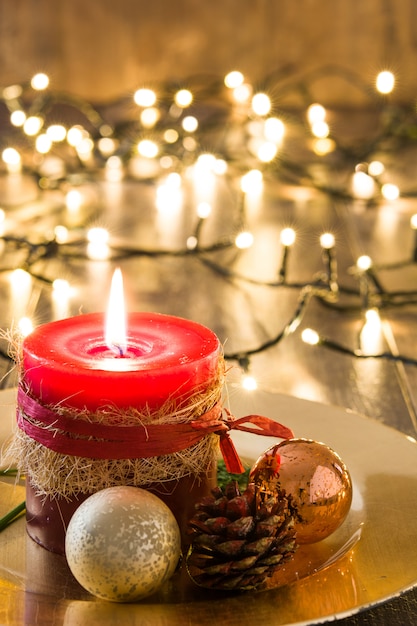 Red Christmas candle and Christmas ornaments on wood