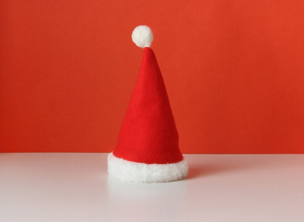 Red Christmas cap on white table and bright front view symbol of New Year