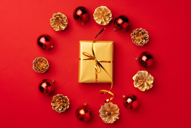 Photo red christmas composition with gold cones and decorations top view