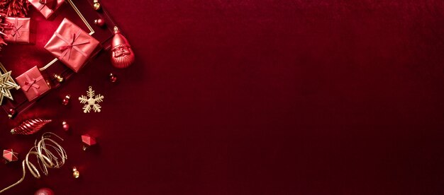 Photo red christmas decoration bauble and ribbon on velvet red felt fabric  top view table backgorund